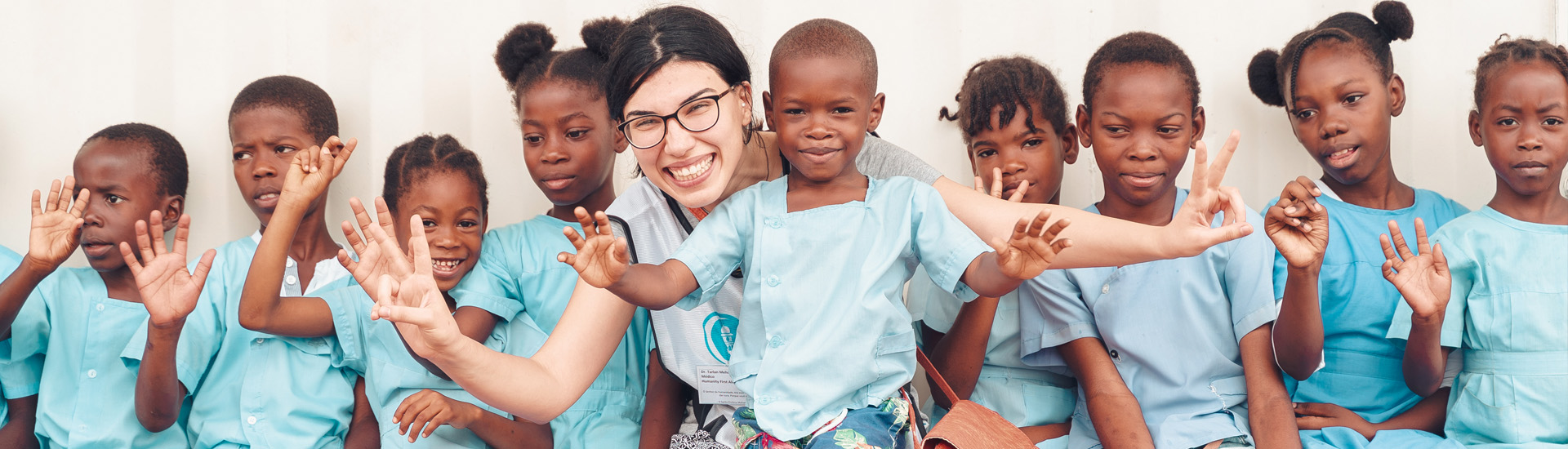 Eine Ärztin von Humanity First mit Kindern in blauer Schulkleidung